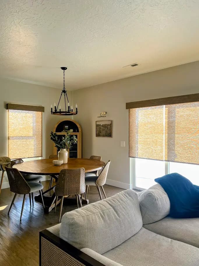 Custom woven shades installed in an open living and dining room